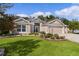 One-story home with a three-car garage, beautiful lawn, and mature landscaping at 2954 Heiny Pl, The Villages, FL 32163