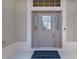 Close-up of the front door featuring decorative glass sidelights, secure lock, and a stylish welcome mat at 2954 Heiny Pl, The Villages, FL 32163