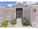 Inviting front entrance with a screened front door, enhanced by lush shrubs at 2954 Heiny Pl, The Villages, FL 32163