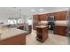 Well-lit kitchen boasts stainless steel appliances, island with storage, and granite countertops at 2954 Heiny Pl, The Villages, FL 32163