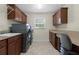 Well-equipped laundry room with modern washer, dryer, ample storage, and counter space for convenience at 2954 Heiny Pl, The Villages, FL 32163