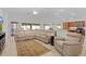 Open-concept living room with a leather sofa, tile floors, and plenty of natural light at 2954 Heiny Pl, The Villages, FL 32163