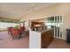 Spacious covered patio with outdoor kitchen, bar, and views of the home's interior and back yard at 2954 Heiny Pl, The Villages, FL 32163