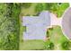 Aerial shot showcasing the house's roof, landscaping, and circular driveway in a lush, green setting at 2991 Saint Thomas Ln, The Villages, FL 32162