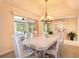 Bright dining room features a chandelier, neutral walls, and sliding glass doors leading to the lanai at 2991 Saint Thomas Ln, The Villages, FL 32162