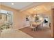 Spacious dining room showcases a tray ceiling with chandelier, adjacent to the kitchen and living room at 2991 Saint Thomas Ln, The Villages, FL 32162