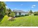 Well-maintained house exterior with green lawn and manicured landscaping with gray awnings at 2991 Saint Thomas Ln, The Villages, FL 32162