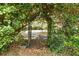 Metal gate surrounded by greenery with a view of the street ahead at 2991 Saint Thomas Ln, The Villages, FL 32162