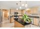 Neutral kitchen features granite countertops, stainless steel appliances, and an island with black countertop at 2991 Saint Thomas Ln, The Villages, FL 32162