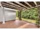 Charming covered patio with tiled floor and a pergola covered in vines offering privacy at 2991 Saint Thomas Ln, The Villages, FL 32162