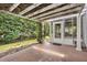 Inviting outdoor tiled patio with a pergola covered in vines next to a screened in porch at 2991 Saint Thomas Ln, The Villages, FL 32162