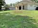 Expansive backyard featuring a covered patio, ceiling fans, and lush green grass at 30604 Apawamis Dr, Sorrento, FL 32776