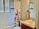 Bright bathroom featuring a shower-tub combo, floral shower curtain, and classic vanity at 30604 Apawamis Dr, Sorrento, FL 32776