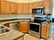 Kitchen featuring wood cabinets, stainless steel appliances, and a neutral countertop at 30604 Apawamis Dr, Sorrento, FL 32776