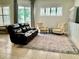 Spacious living room featuring a leather sofa, two armchairs, an area rug, and lots of natural light at 30604 Apawamis Dr, Sorrento, FL 32776