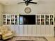 Living room with built-in shelving, a flat-screen TV, and comfortable armchair at 30604 Apawamis Dr, Sorrento, FL 32776