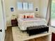 Comfortable main bedroom with a queen-size bed, leather bench and bright window at 30604 Apawamis Dr, Sorrento, FL 32776