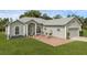 Inviting home featuring a brick-paved seating area and lovely landscaping at 316 Dupont Cir, Howey In The Hills, FL 34737