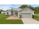 Charming single-story home with a well-manicured lawn and a brick-paved seating area at 316 Dupont Cir, Howey In The Hills, FL 34737