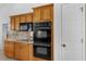 Well-equipped kitchen with light wood cabinets and built-in black microwave and ovens at 316 Dupont Cir, Howey In The Hills, FL 34737