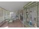 Sunny porch area with tile floors, decorative shelving, and comfortable dining area at 316 Dupont Cir, Howey In The Hills, FL 34737