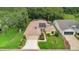 An aerial view showing the house, well maintained lawn, beautiful landscaping and solar panels at 32948 Rambling Oaks Ct, Leesburg, FL 34748