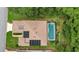 An aerial view of the house showing roof solar panels and screened in backyard pool at 32948 Rambling Oaks Ct, Leesburg, FL 34748