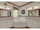 Bathroom featuring a jacuzzi tub, double sinks, and floral wallpaper trim at 32948 Rambling Oaks Ct, Leesburg, FL 34748