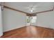 Well-lit bedroom with wood-look floors, floral wallpaper trim, and a ceiling fan for added comfort at 32948 Rambling Oaks Ct, Leesburg, FL 34748