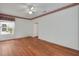 Bright bedroom with hardwood floors, floral wallpaper trim, and a ceiling fan at 32948 Rambling Oaks Ct, Leesburg, FL 34748