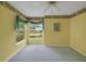 Bright bedroom with ceiling fan, carpet, and view of the front yard at 32948 Rambling Oaks Ct, Leesburg, FL 34748