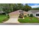 Charming single-story home with well-manicured lawn, two car garage, and mature landscaping at 32948 Rambling Oaks Ct, Leesburg, FL 34748