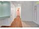 Hallway with neutral walls, wood floors, and tiled entryway leading to bedrooms at 32948 Rambling Oaks Ct, Leesburg, FL 34748