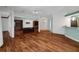 Open-concept living room featuring hardwood floors, custom built-ins, and a light mint accent wall at 32948 Rambling Oaks Ct, Leesburg, FL 34748