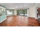 Spacious living room featuring wood floors, large windows, and seamless access to the screened-in pool at 32948 Rambling Oaks Ct, Leesburg, FL 34748