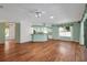 Open-concept living room with wood floors, ceiling fan, and view of the kitchen and backyard at 32948 Rambling Oaks Ct, Leesburg, FL 34748