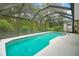 Screened-in pool area with lush landscaping, providing privacy and a tropical feel at 32948 Rambling Oaks Ct, Leesburg, FL 34748