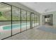 Enclosed pool room with tiled floors and sliding glass doors with views of the pool and backyard at 32948 Rambling Oaks Ct, Leesburg, FL 34748