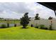 Beautiful backyard featuring a pond with black metal fence, lush lawn, and flower planters at 33647 Sky Blossom Cir, Leesburg, FL 34788