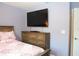 Bedroom featuring a flat screen TV, dresser, and a wooden bed frame with floral bedding at 33647 Sky Blossom Cir, Leesburg, FL 34788