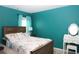 Stylish bedroom with a wooden bed frame, turquoise walls, and a vanity with mirror at 33647 Sky Blossom Cir, Leesburg, FL 34788