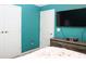 Bedroom featuring turquoise walls, a flat screen tv, and two closets with white doors at 33647 Sky Blossom Cir, Leesburg, FL 34788