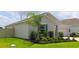 Charming one-story home featuring a landscaped yard with a palm tree and green shutters at 33647 Sky Blossom Cir, Leesburg, FL 34788