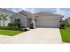 Charming single-story home with a well-maintained lawn and a spacious driveway at 33647 Sky Blossom Cir, Leesburg, FL 34788