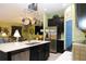 Open-concept kitchen boasts stainless steel appliances, an island with sink, and seamless flow into living area at 33647 Sky Blossom Cir, Leesburg, FL 34788