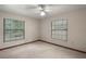 Neutral carpeted bedroom with ceiling fan and windows offering natural light at 37236 Cherry Lake Rd, Fruitland Park, FL 34731