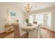 Sunlit dining room featuring a chandelier, crab artwork, and bay window at 37236 Cherry Lake Rd, Fruitland Park, FL 34731