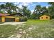 View of the house and detached garage featuring a spacious driveway and expansive lawn at 37236 Cherry Lake Rd, Fruitland Park, FL 34731