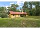 Charming single-story home boasts a bright exterior, red roof, and a spacious green lawn at 37236 Cherry Lake Rd, Fruitland Park, FL 34731