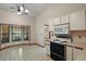 Bright kitchen features tile flooring, white cabinets, modern appliances, and a bay window with natural light at 37236 Cherry Lake Rd, Fruitland Park, FL 34731